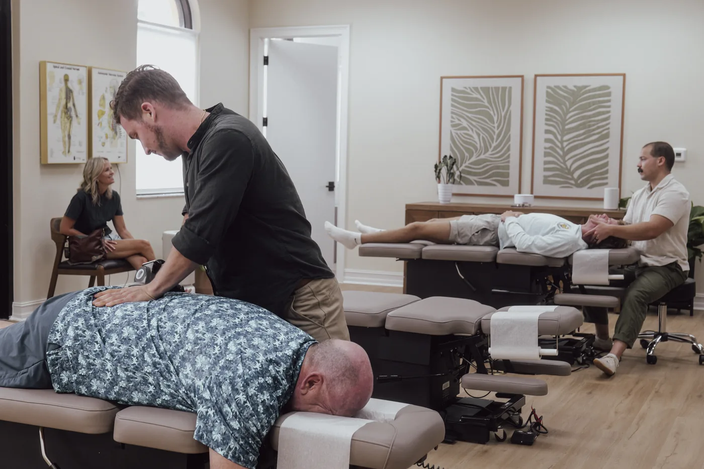 Dr. Jarod Ward and Dr. Diego Torres adjusting patients at Crown Chiropractic's Parker Commons office in Fort Myers
