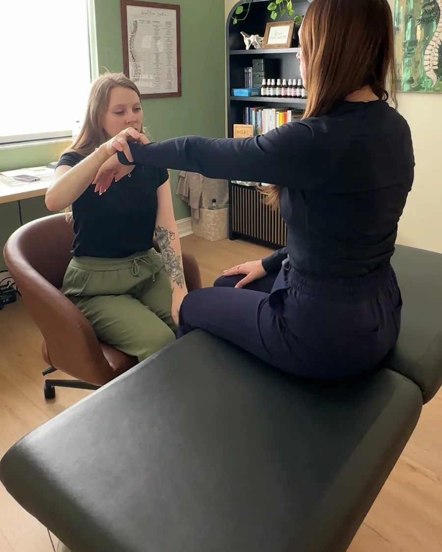 Dr. Leah muscle testing a seated patient during Neuro-Emotional Technique (NET) in Fort Myers